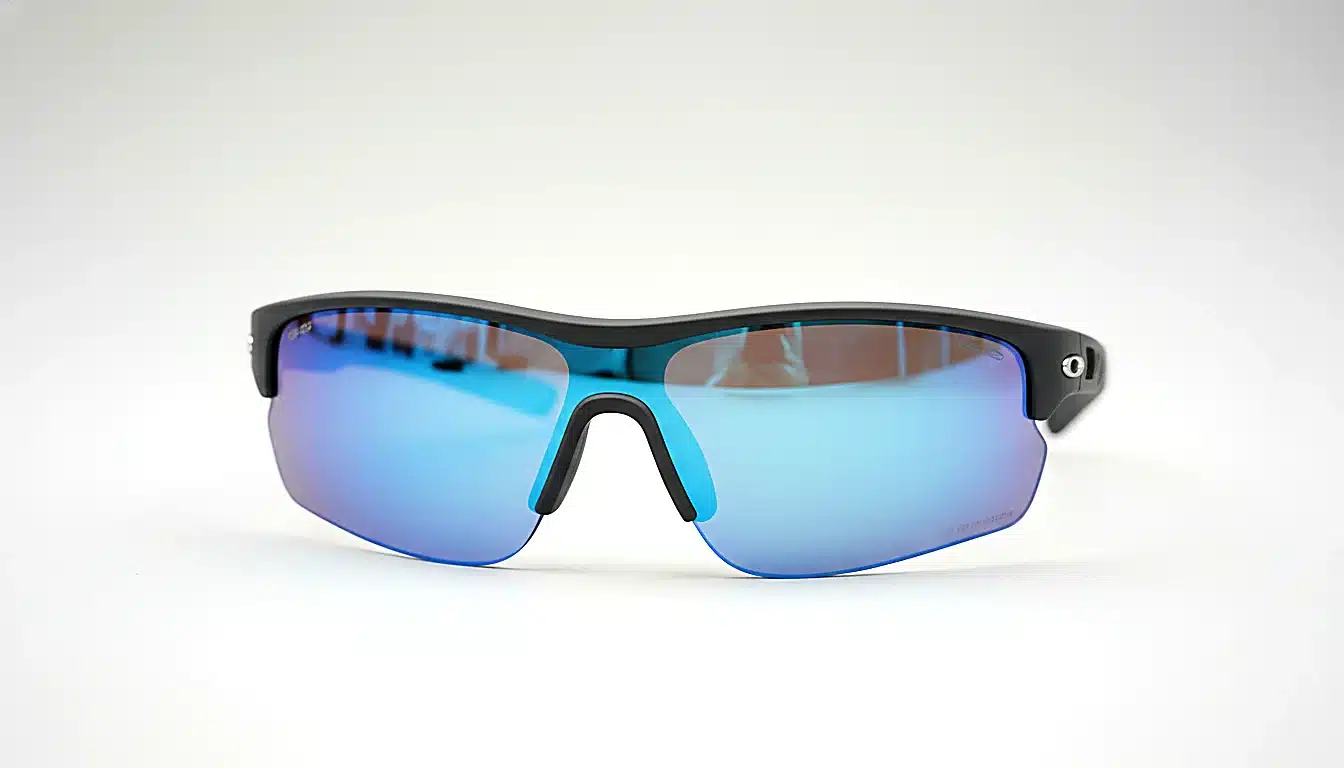 Lunettes de sport avec monture wrap-around posées sur surface neutre, détail produit