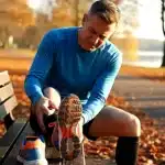 Coureur senior massant son talon douloureux epine calcaneenne