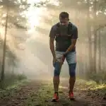 Coureur souffrant d periostite tibiale sur sentier au lever du jour